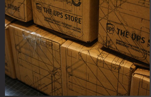Kraft shipping boxes printed with a blueprint pattern for The UPS Store