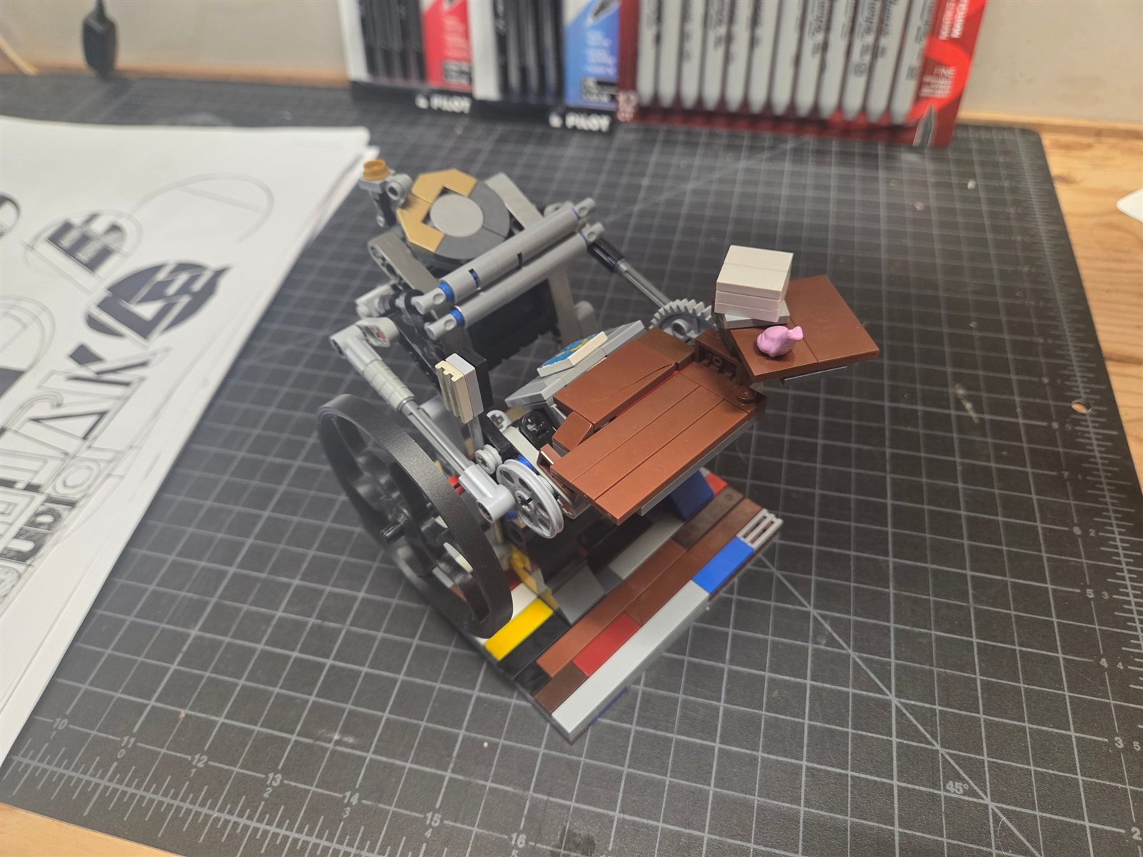 A working model letterpress built from interlocking bricks on a studio cutting mat